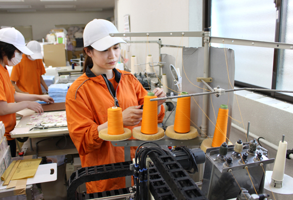 機械を使って作業する女性社員